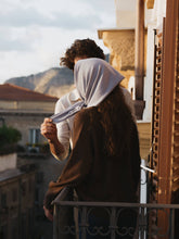 Load image into Gallery viewer, Two people embracing on a balcony with a scenic mountain view.