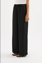 Load image into Gallery viewer, Black wide-leg pants worn by a person on a white background