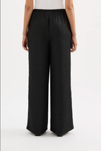 Load image into Gallery viewer, Person wearing black wide-leg pants on a white background