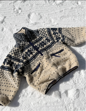Load image into Gallery viewer, Beige and navy patterned fleece sherpa on a snowy ground